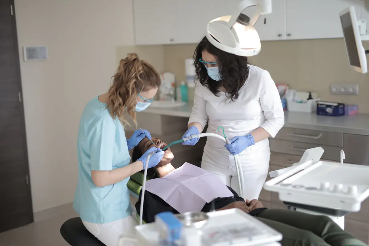 A dentist and assistant examining a patient in a modern clinic