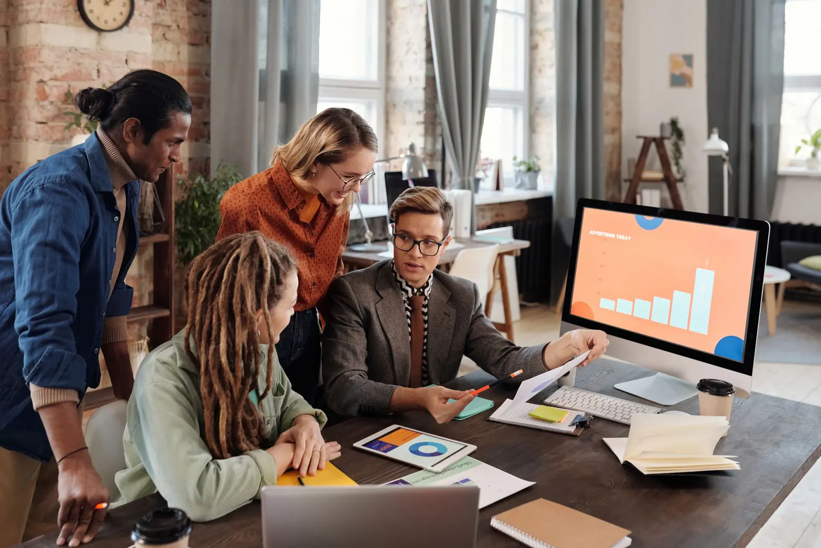Colleagues gathered round a desktop screen showing a growth chart